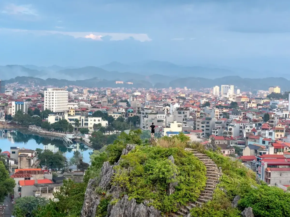 A lakeside city seen from a rocky mountain top